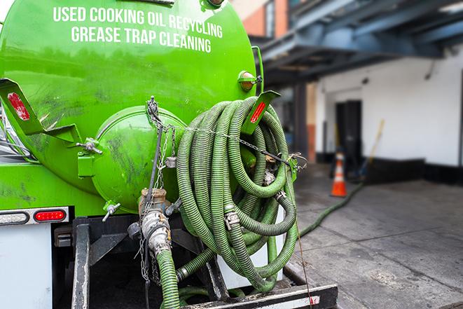 a technician pumping a grease trap in a commercial building in Los Alamitos, CA